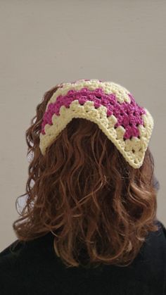 a woman with long hair wearing a crocheted hat