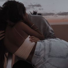 two people embracing each other in front of a sunset