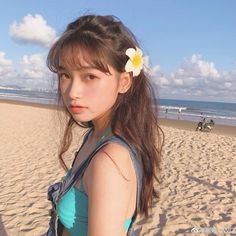 a girl with a flower in her hair on the beach