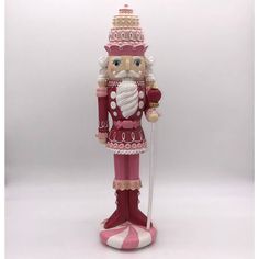 a pink and white nutcracker figurine with a cane in it's hand