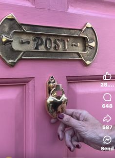 a person's hand is holding a key to a pink door with the word post on it