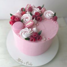 a pink cake decorated with raspberries and flowers