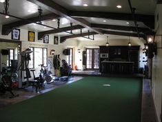 an indoor gym with green carpet and lots of exercise equipment