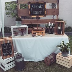 a table topped with wooden crates filled with food next to a sign that says oscar's party