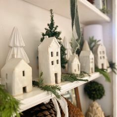 some white houses and pine cones on a shelf