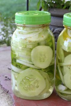 two mason jars filled with pickles and onions