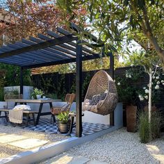 an outdoor dining area with chairs, table and hanging hammock in the middle