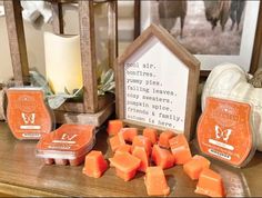 some candles are sitting on a table next to pumpkins and other items for decor