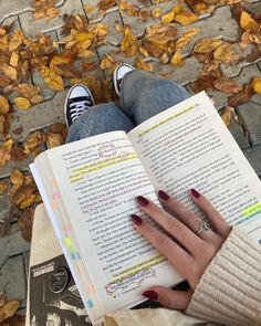 a woman is reading a book on the ground