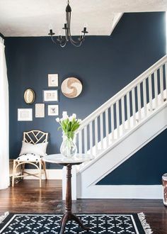 a living room with blue walls and white stairs