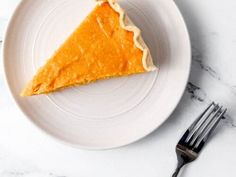 a piece of pie on a white plate next to a fork