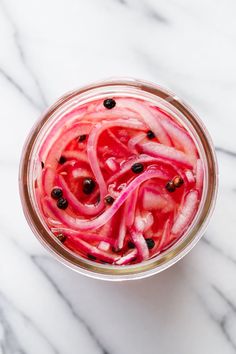 a jar filled with pickled onions on top of a marble counter