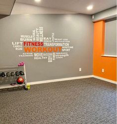 an exercise room with gray carpeting and orange walls, there is a gym equipment set up in front of the wall