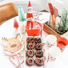 a table topped with chocolate covered donuts and christmas decorations