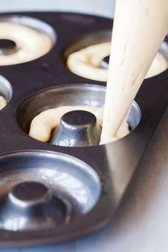 a person pouring batter into a muffin tin