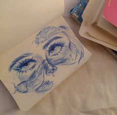 an open notebook with a drawing of a woman's eye