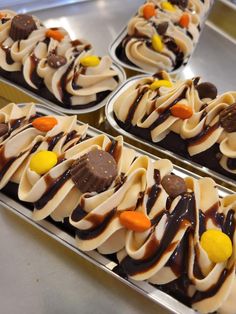 four trays filled with cupcakes covered in chocolate and candy