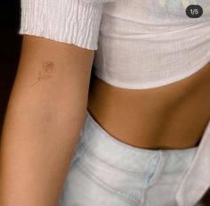 a woman with a small rose tattoo on her left arm and lower half of her body