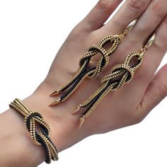 a woman's hand with two bracelets on it, one is gold and the other is black