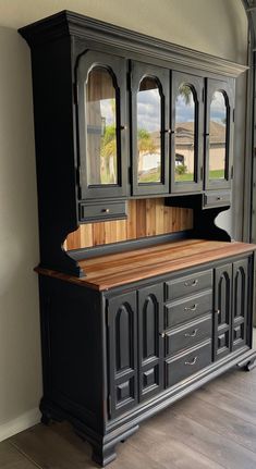 a black china cabinet with wooden top and drawers