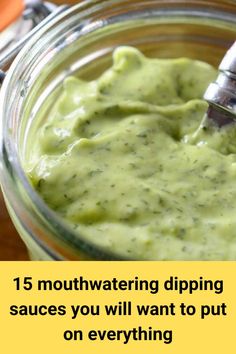 a glass jar filled with green sauce on top of a wooden table