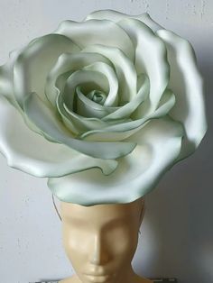 a mannequin head with a large white rose on it's top and bottom