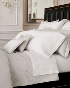 a white bed topped with lots of pillows