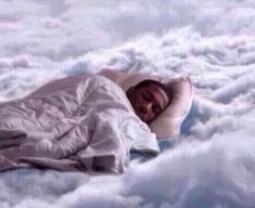 a man is sleeping in the clouds with his head on top of a pillow that looks like he has fallen asleep