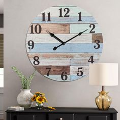 a large clock on the wall in a living room with flowers and vases next to it