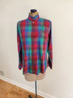 This vintage shirt is a darling addition to any wardrobe. Kelly Harper Petites 55% cotton / 45% polyester Made in Hong Kong The shirt features a plaid pattern in red, blue, and green. Tag size: 12 Shoulder to hem length: 21.5 inches Sleeve length: 22.25 inches Chest: 39 inches The shirt is in great vintage condition. Feel free to send me any questions! Casual Multicolor Cotton Blouse, Preppy Green Tops For Fall, Green Preppy Tops For Fall, Retro Long Sleeve Relaxed Fit Blouse, Plaid Long Sleeve Shirt For Daywear, Collared Plaid Tops For Daywear, Plaid Collared Top For Daywear, Retro Blouse With Relaxed Fit And Long Sleeves, Multicolor Relaxed Fit Cotton Blouse