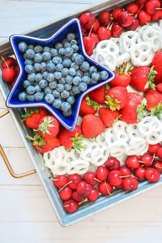 an american flag tray with strawberries, blueberries, and pretzels in it