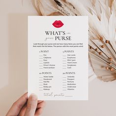 a person holding up a printable what's in the purse list with feathers