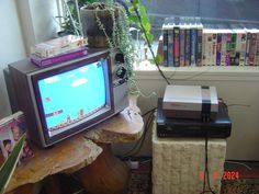 an old computer monitor sitting on top of a wooden table next to a book shelf