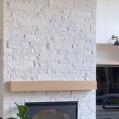 a living room with a white brick fireplace