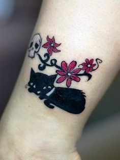 a cat and flower tattoo on the wrist