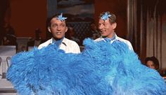 two men with blue feathers on their heads