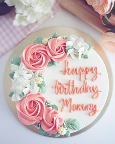 a birthday cake decorated with pink and white flowers