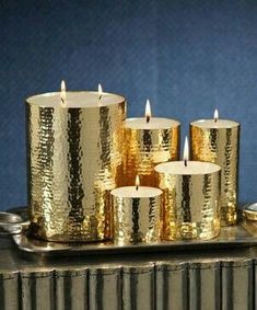 gold colored candles sitting on top of a metal tray