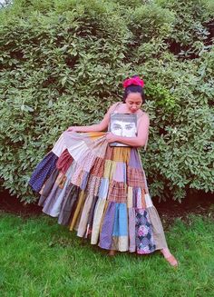 a woman in a multicolored dress is holding a book