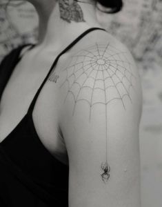 a woman with a spider web tattoo on her shoulder