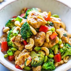 a white bowl filled with broccoli, cashews and chicken