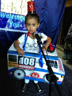 a young boy standing in front of a microphone with a sign on it that says welcome to you