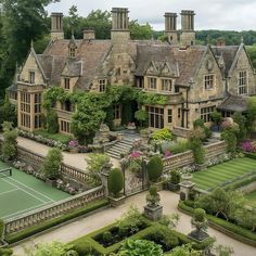 an aerial view of a large house with tennis court in the foreground and lots of greenery