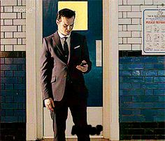 a man in a suit is looking at his cell phone