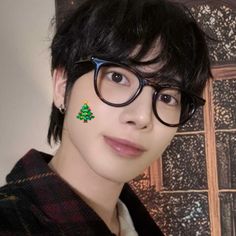 a young man wearing glasses with a christmas tree on his forehead and eyeliners