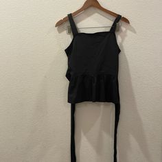 Brand New With Tag Anthropologie Black Top That Ties In Front Once Then In The Back Into A Bow Black Stretch Top With Tie Back, Black Tie Back Top For Day Out, Black Cotton Tank Top For Party, Black Casual Tops With Tie Back, Casual Black Tops With Tie Back, Black Tie Back Top For Summer, Black Sleeveless Top With Tie Back, Fitted Black Tank Top With Tie Back, Black Cotton Tie Back Top