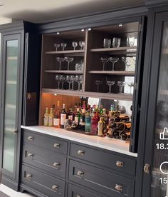 a bar with lots of bottles and glasses on it's counter top in a kitchen