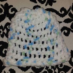 a crocheted hat is sitting on a black and white blanket