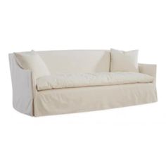 a white couch sitting on top of a white floor next to a pillow and pillows