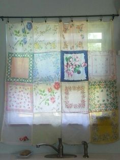 a bathroom with a sink and shower curtain made out of old handkerchiefs on the wall